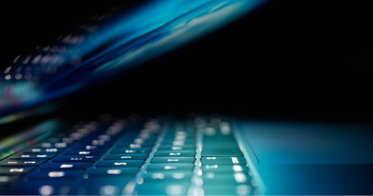 A laptop sitting on a table halfway open with the screen on