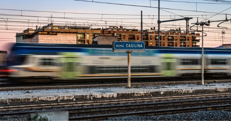 Train passing in a blur with a sign reading 'Roma Casilina'