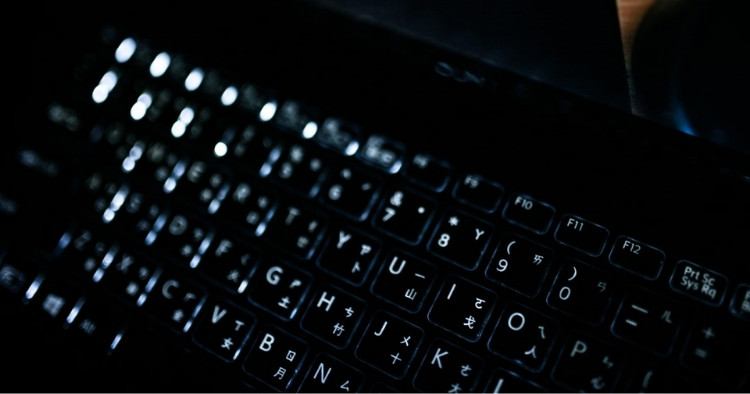 Black keyboard with foreign symbols on it as well as English letters