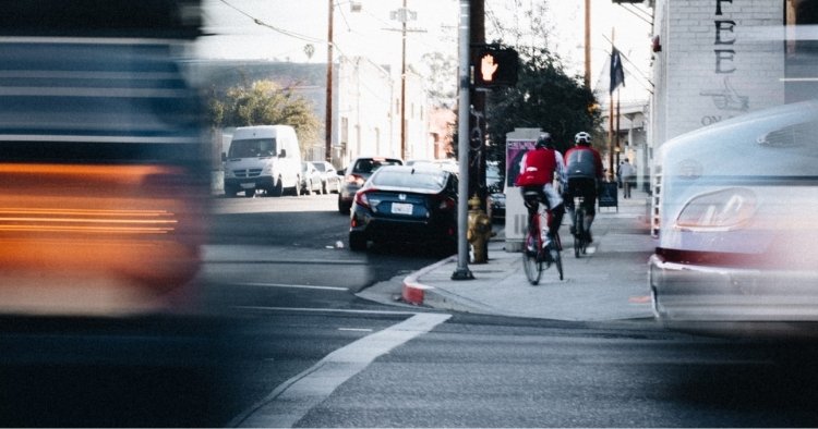 Two cars driving on the road with one right behind representing tailgating someone with your car